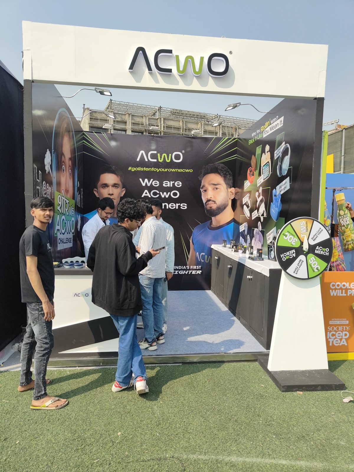 ACWO outdoor booth with branded arch, graphic wall, product counter and prize wheel