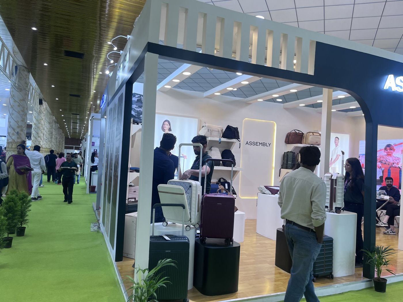 Corner of the Assembly stall with fin parapet, side graphics and suitcases on black and white plinths