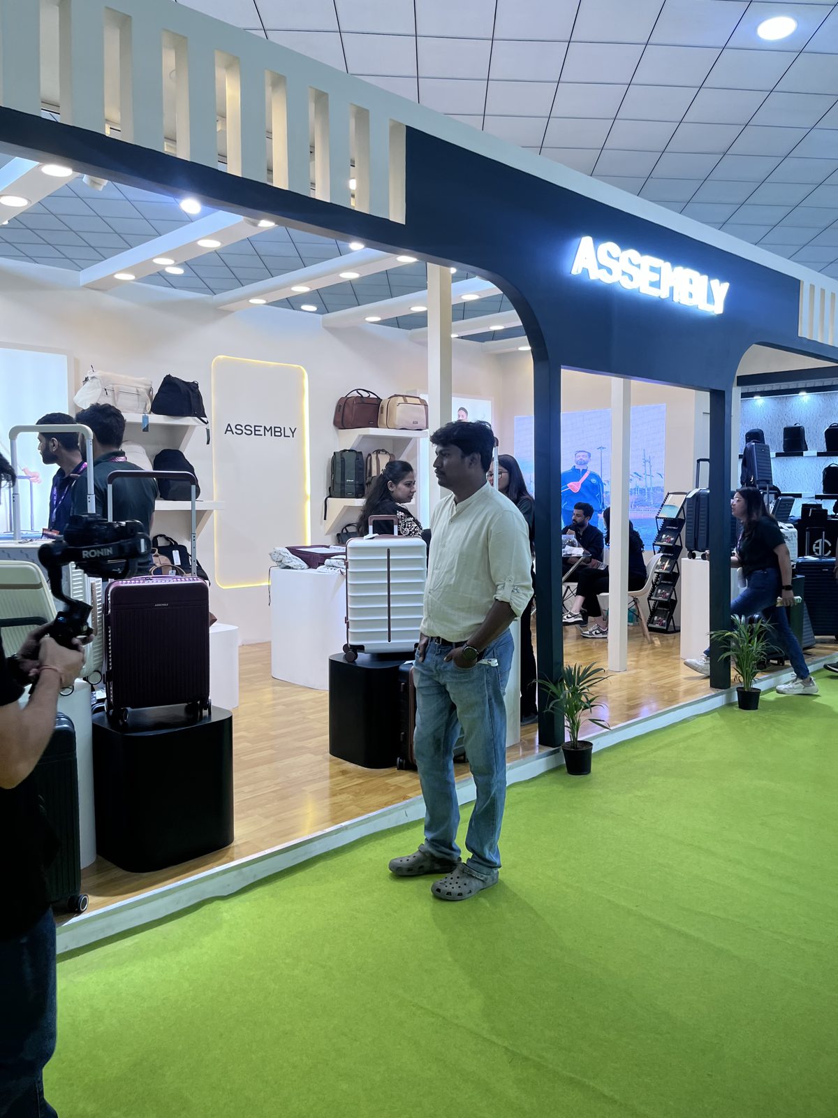 Assembly stall corner with suitcases on plinths and the backlit name