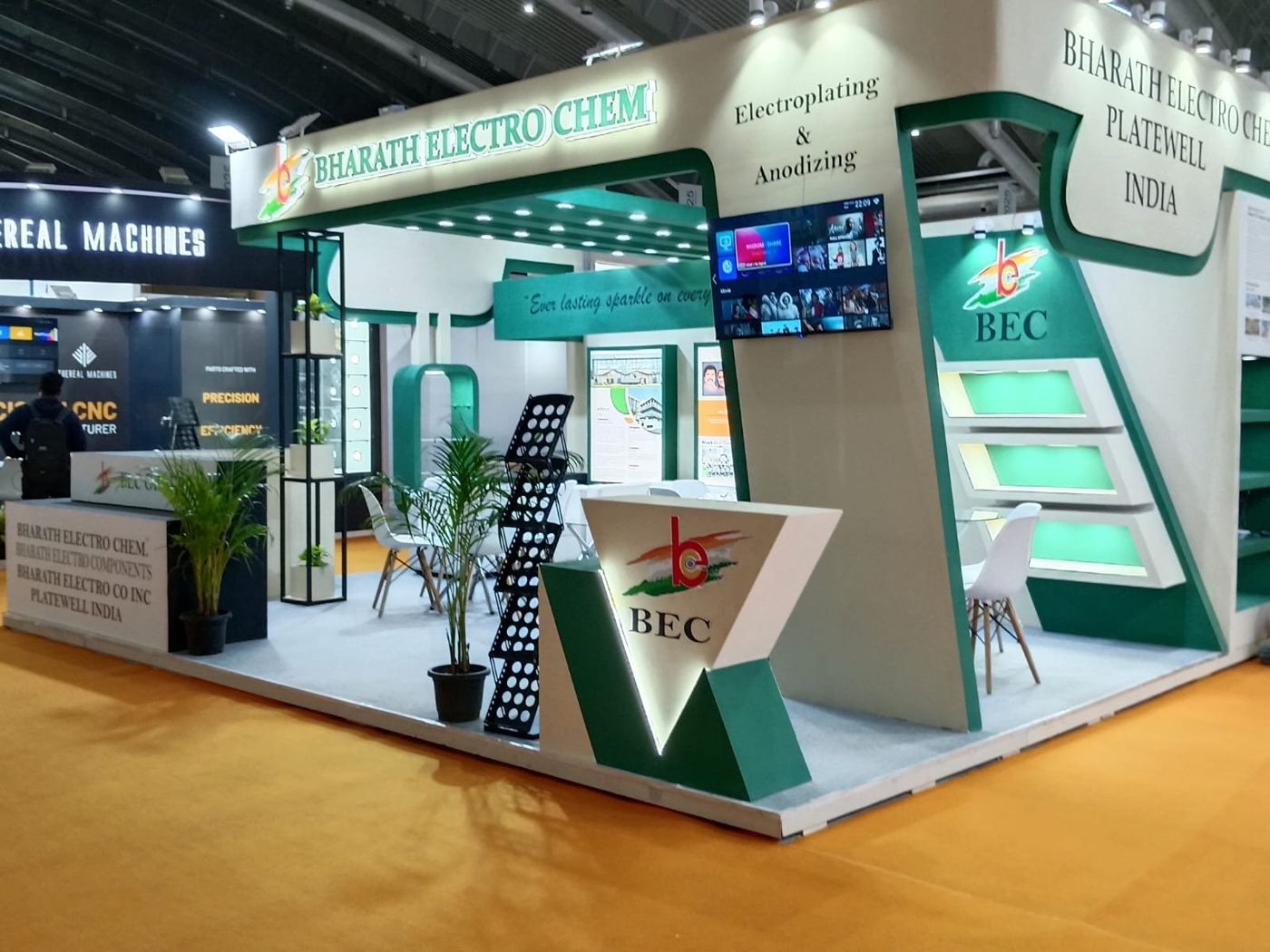 BEC stall corner with V-shaped backlit counter, angled green-lit shelves and a screen