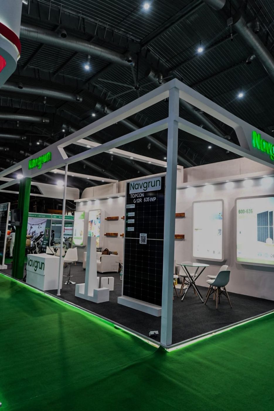 Corner of the stall with an upright solar module, white plinth and green LED strip along the platform base