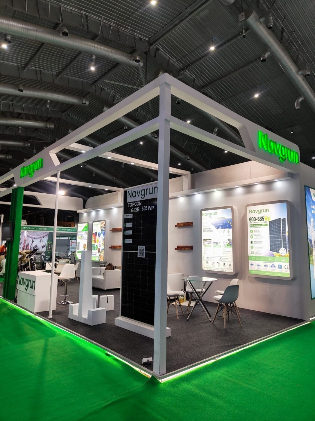 Front corner view of the white frame structure, green backlit lettering and lightbox panels inside