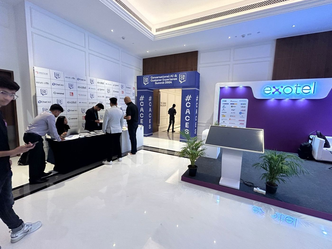 Registration area, entry arch and Exotel lounge set with purple back wall and backlit logo