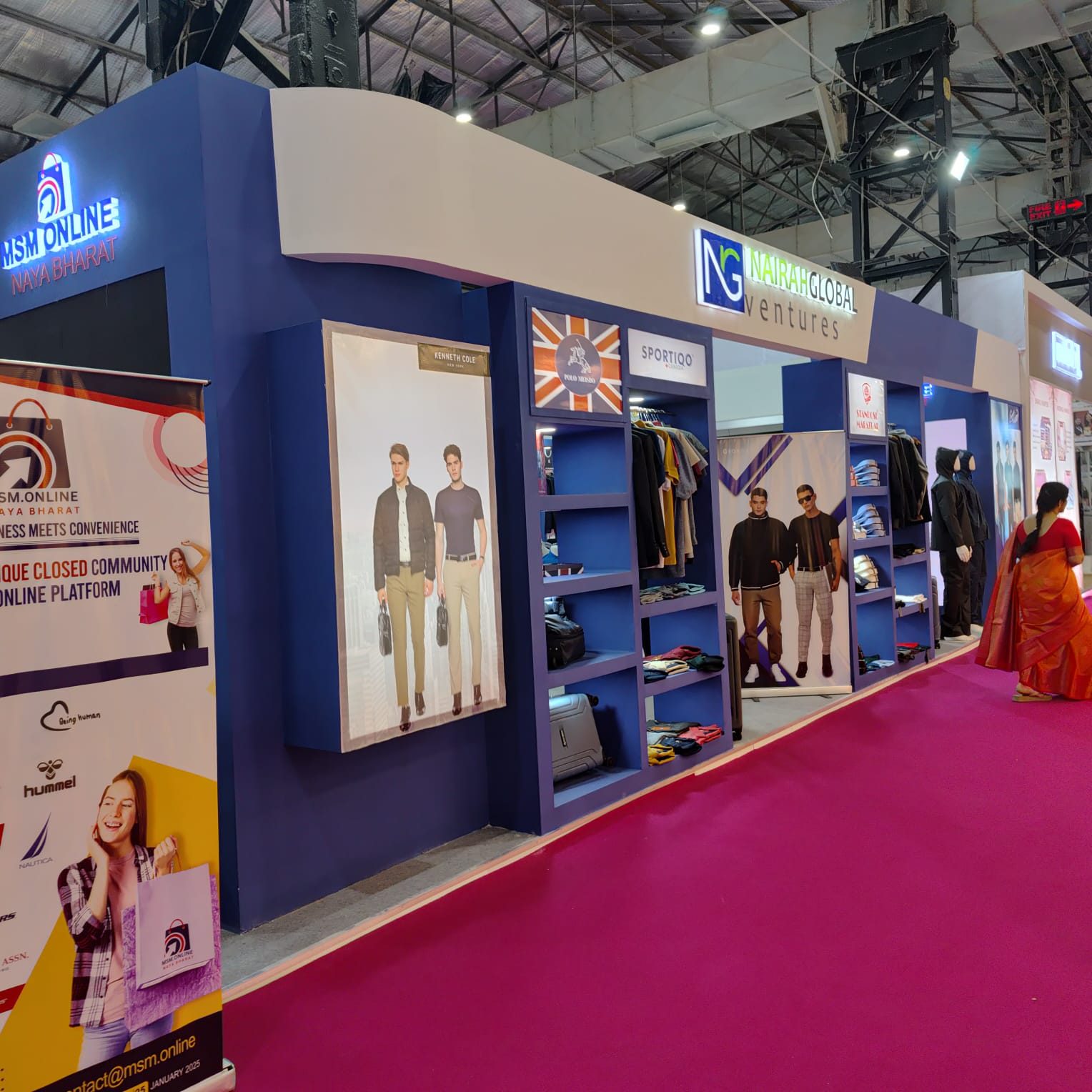 Blue stall front with brand panels and apparel display along the aisle