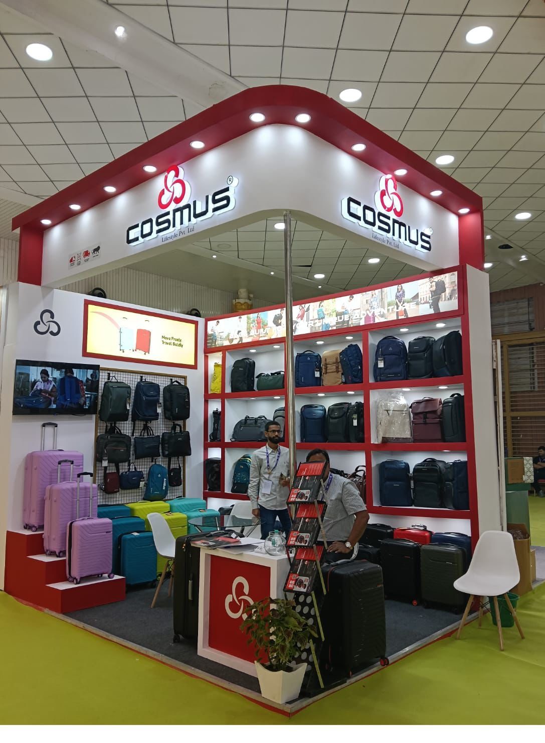 Cosmus corner stall with red fascia, shelving wall of bags and luggage display