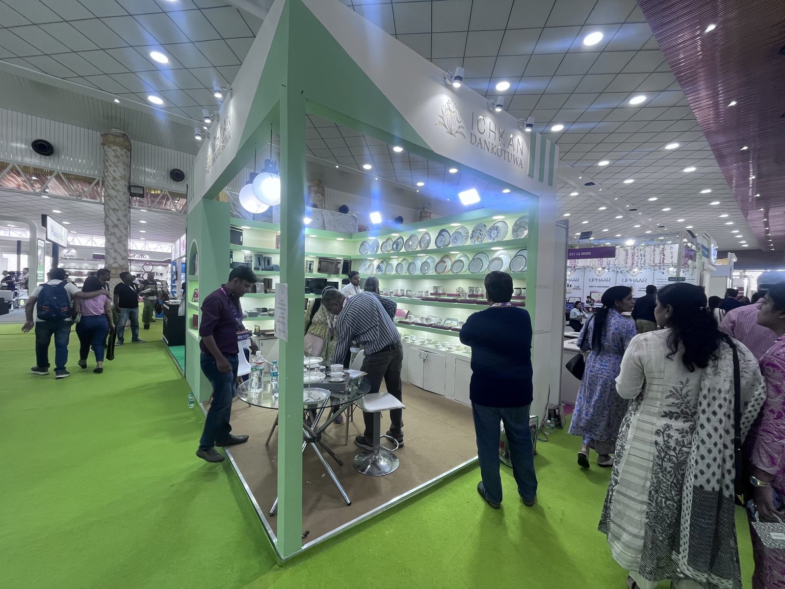 Dankotuwa mint green stall with plate shelving, globe lights and visitors