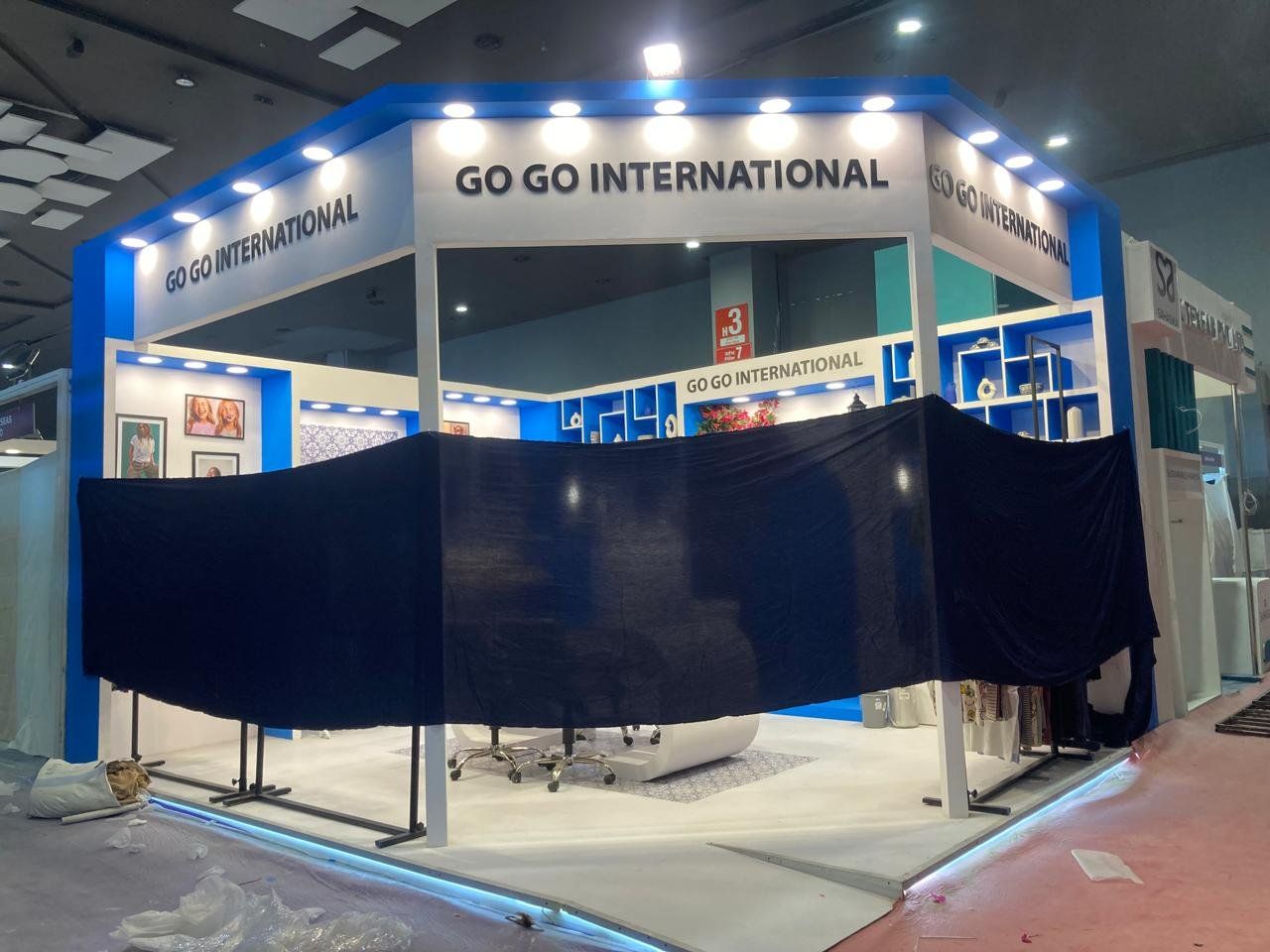 Go Go International stall during build-up with a dark cloth draped across the front