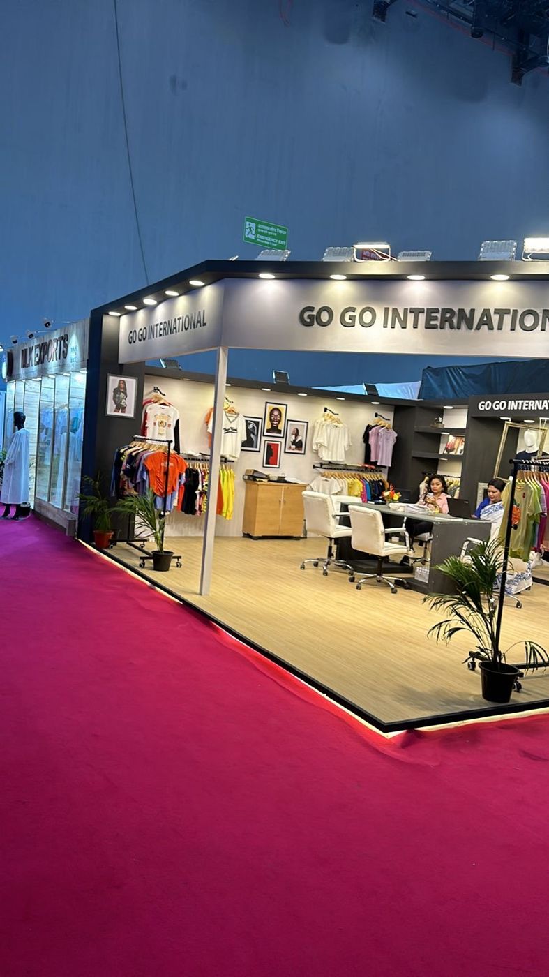 Side view of Go Go International stall showing fascia lettering and lit platform edge on maroon carpet