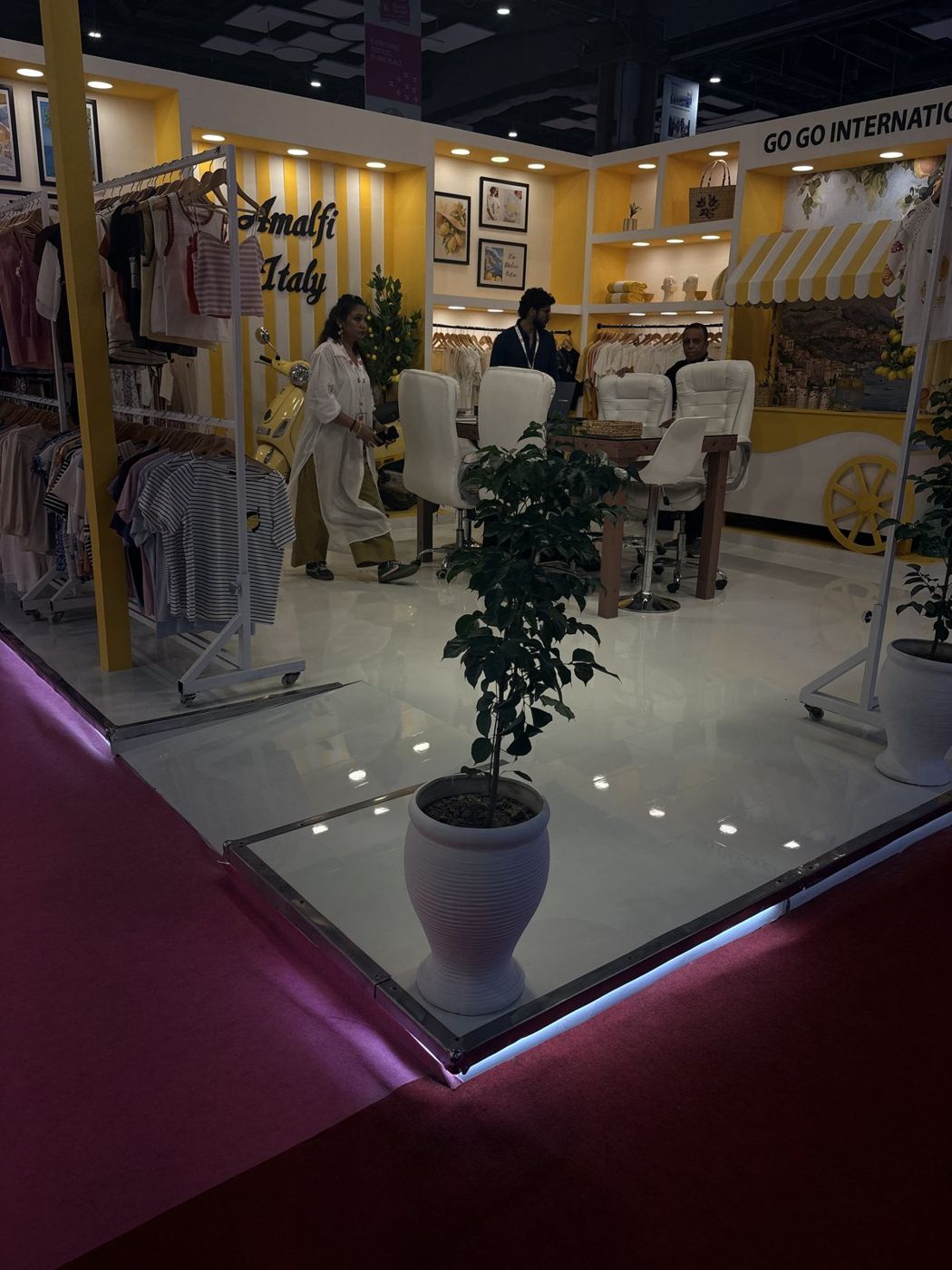 Glossy white platform with LED edge, Amalfi Italy lettering, yellow scooter and wheeled cart