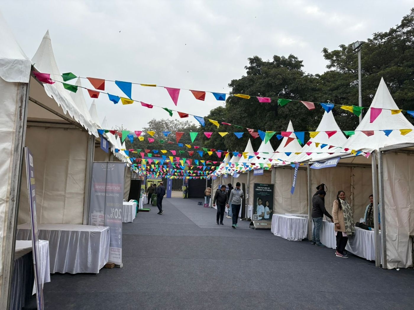 Carpeted walkway lined with white pagoda tent stalls and colourful bunting overhead