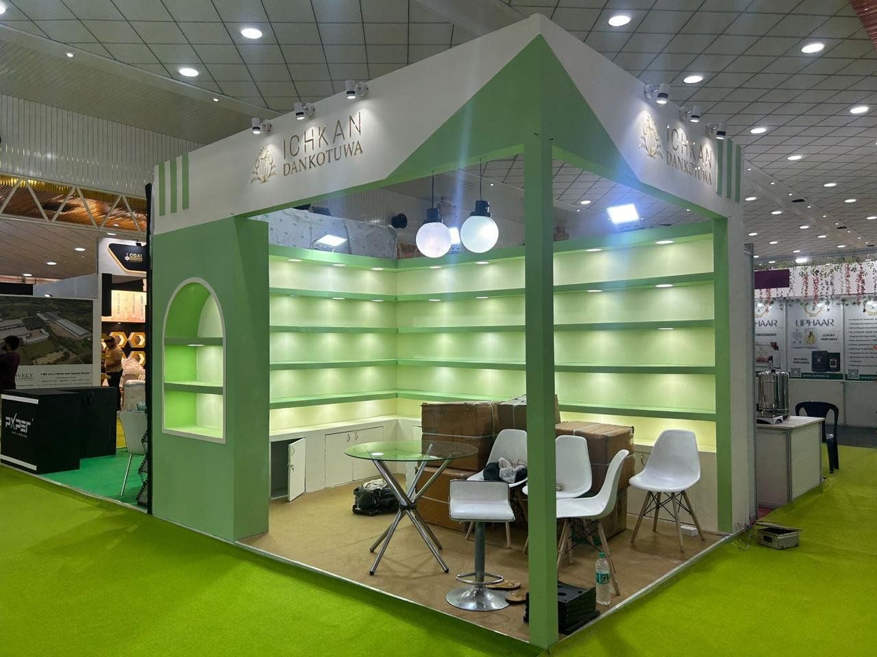 Green gabled corner stall with empty lit shelves, base cabinets and white chairs