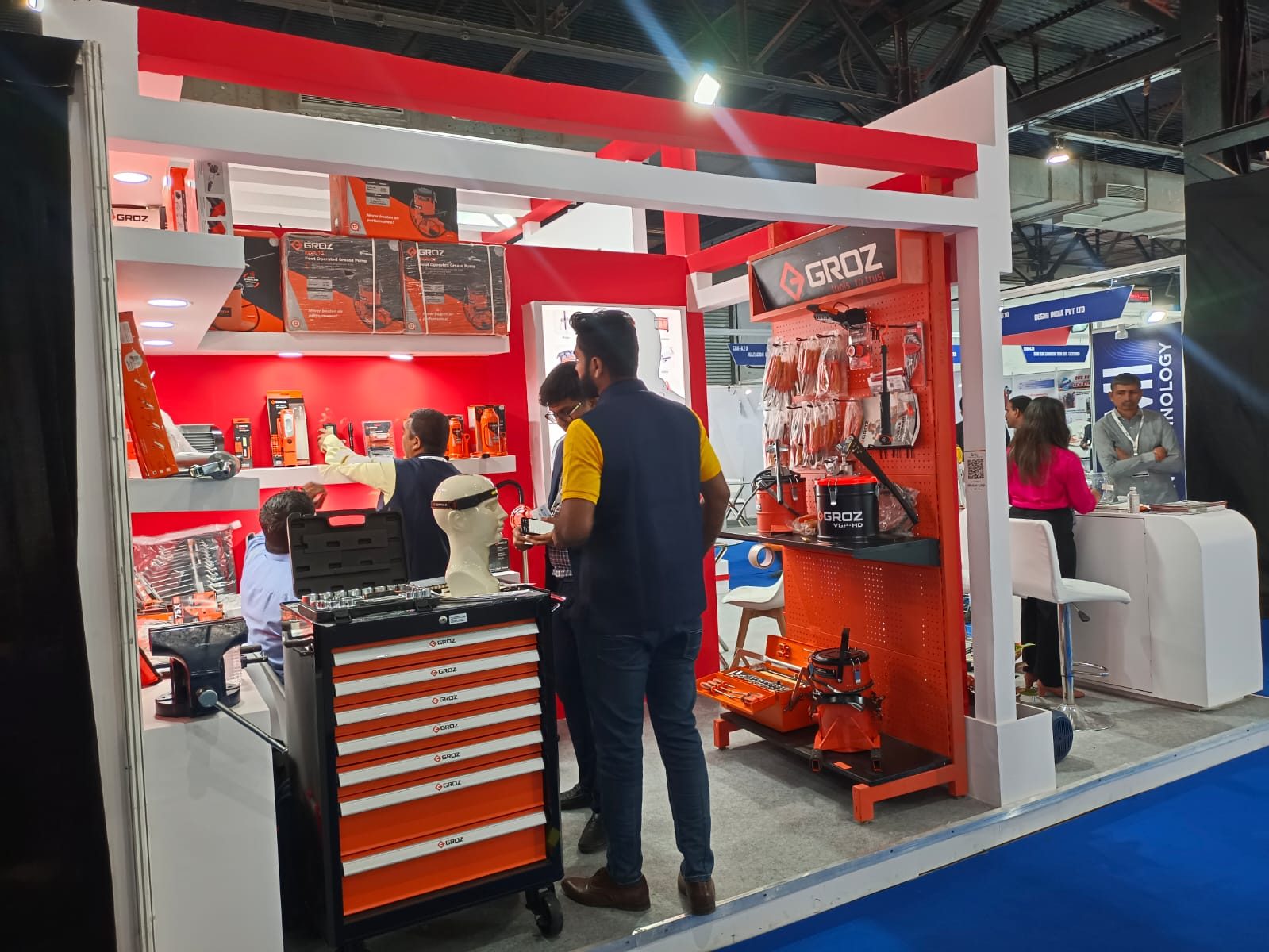 Groz stall with orange pegboard, red walls, white shelves and tool cabinet