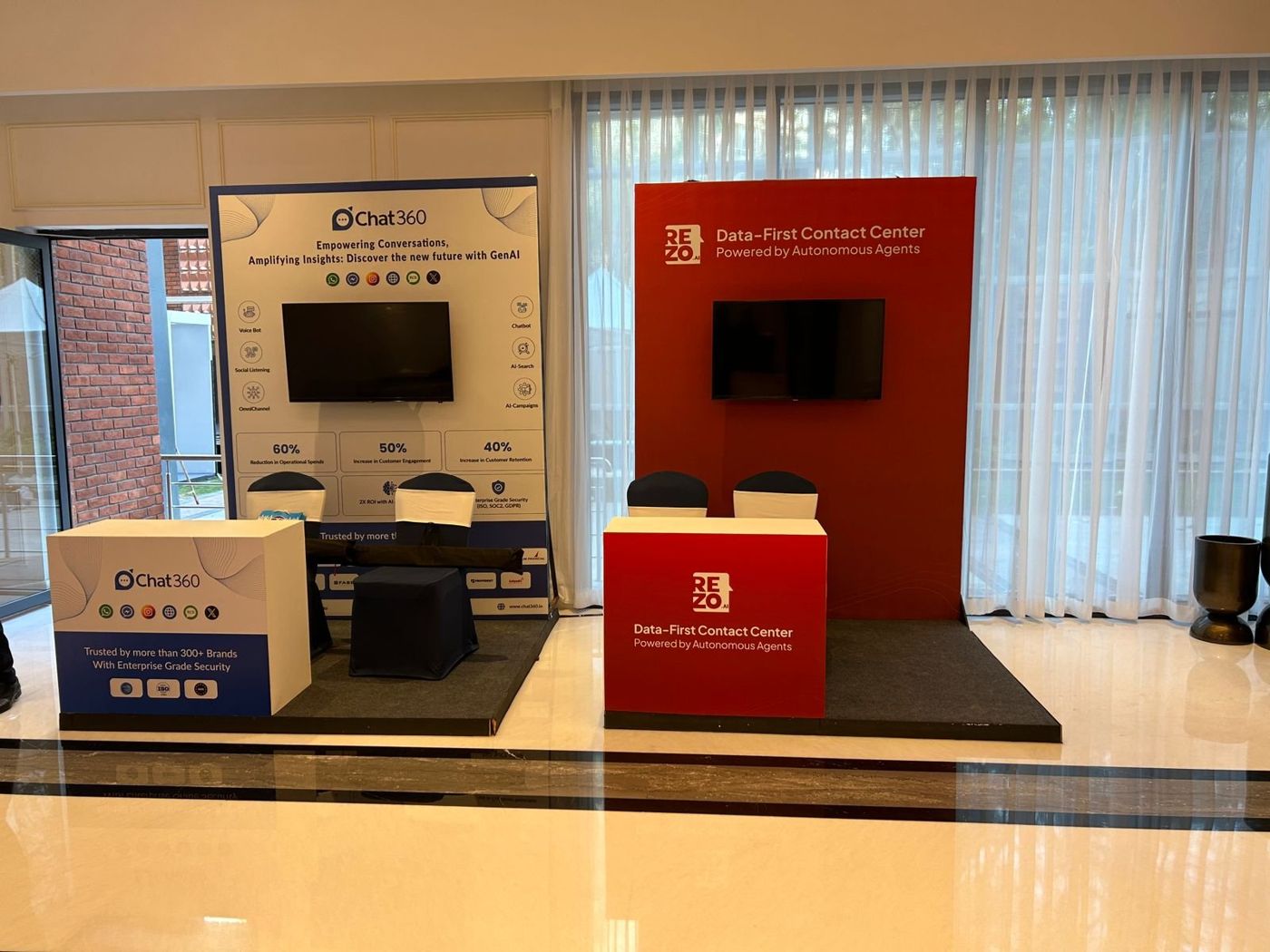 Chat360 booth in blue and white beside the red Rezo booth, each with a screen and branded counter