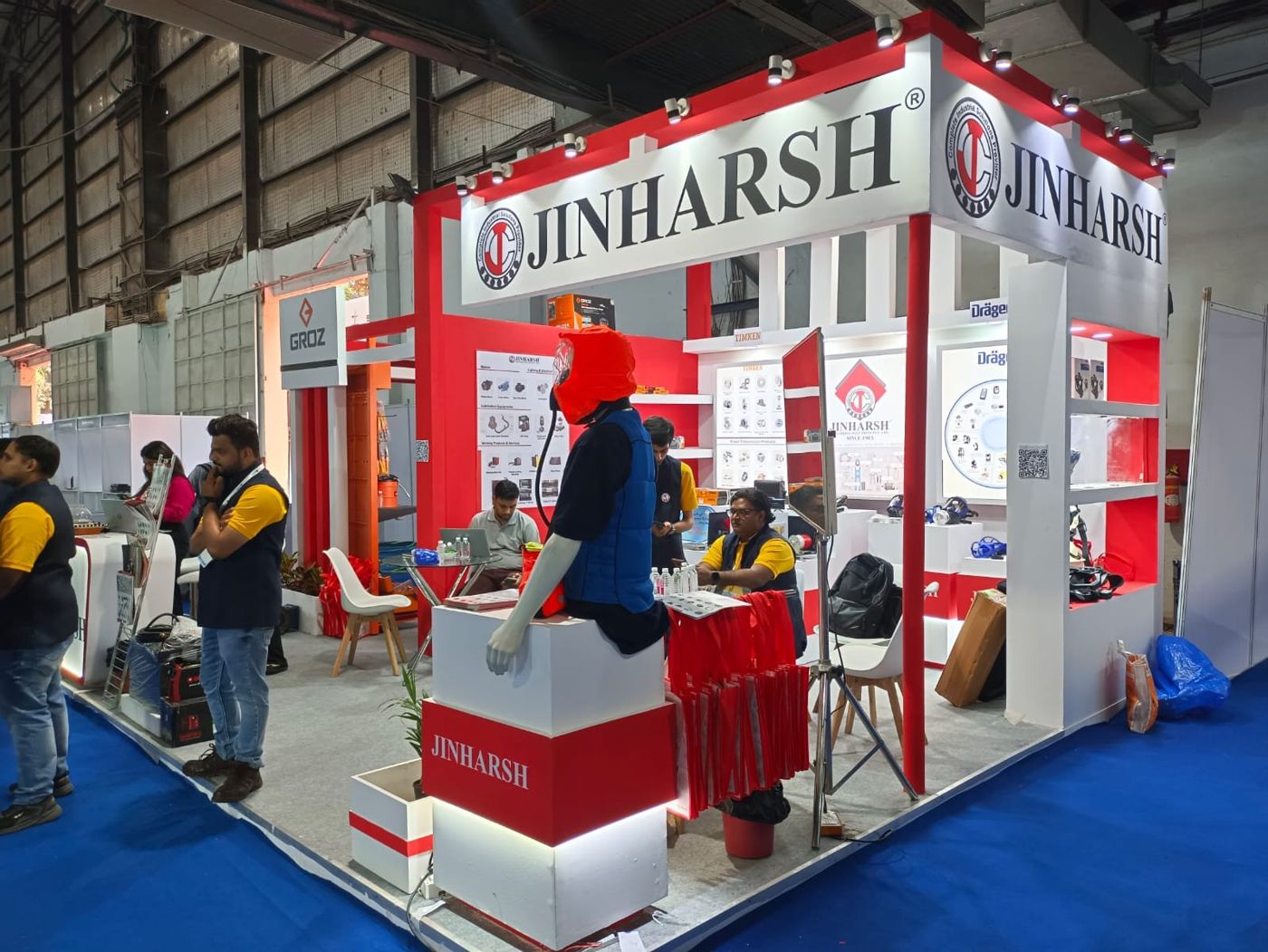 Jinharsh corner stall with red frame, white logo fascia on two sides and a mannequin on a red and white plinth