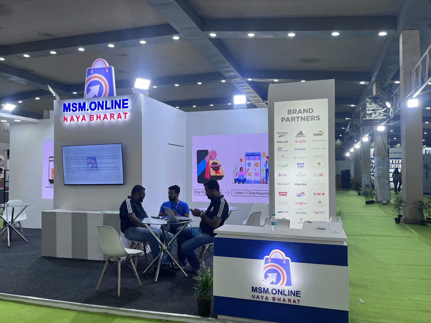 MSM Online stall with backlit tower signage, graphic walls, brand partner totem and reception counter
