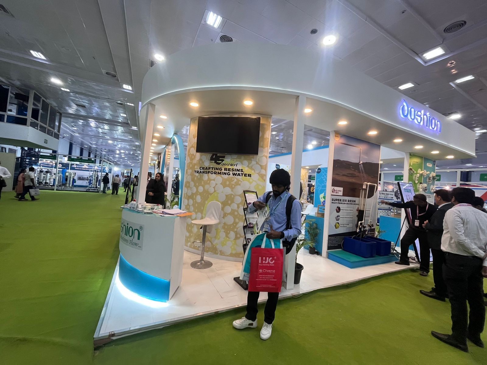 Oushion curved white stall with backlit logo, bubble feature wall and lit counter