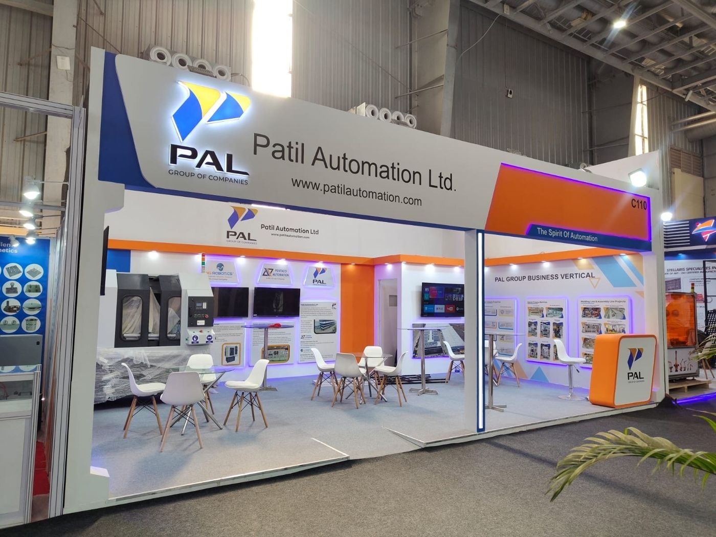 Patil Automation stall with a white fascia, backlit PAL logo, blue and orange panels and a machine on display