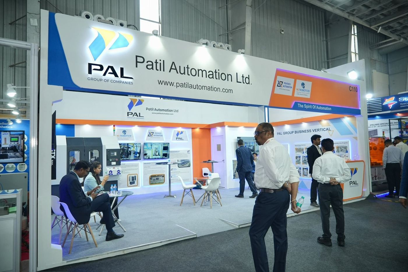 Patil Automation stall during the show with meetings at glass tables and edge-lit panels on the walls