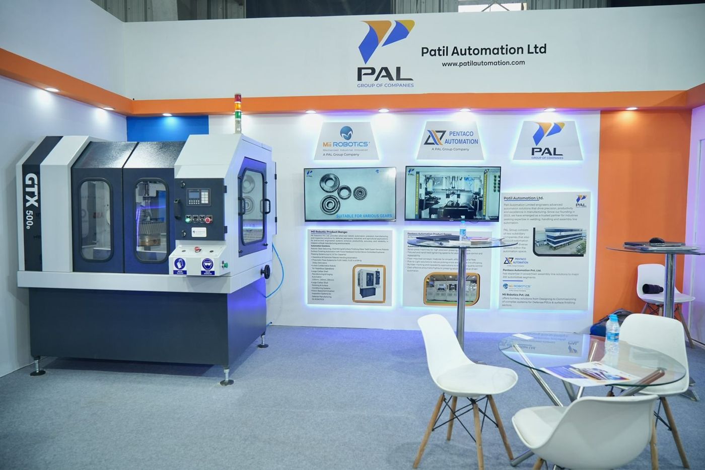 Machine on display beside raised, edge-lit logo panels for PAL group companies and two wall screens