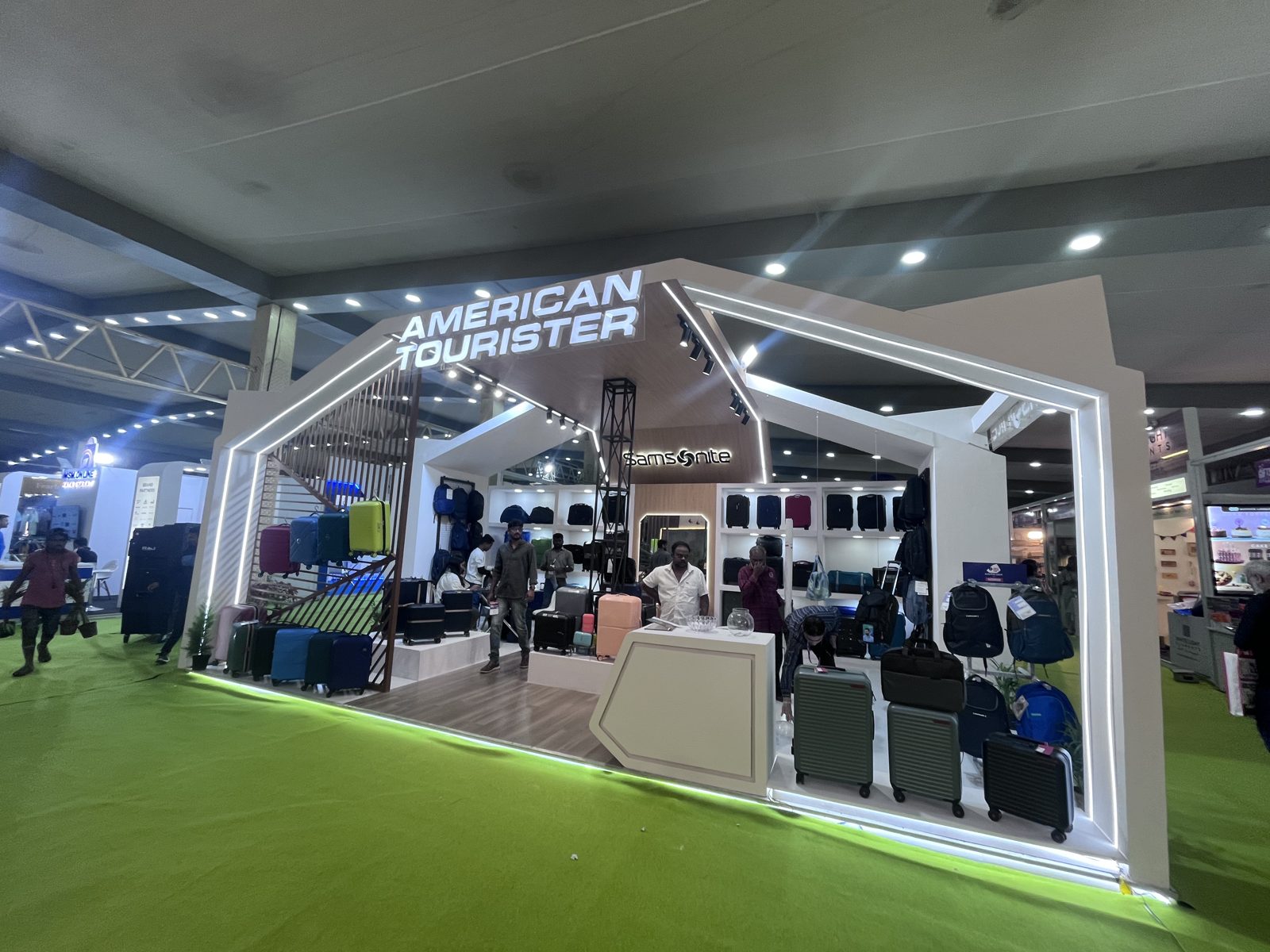 American Tourister section with lit house-shaped frame and luggage display
