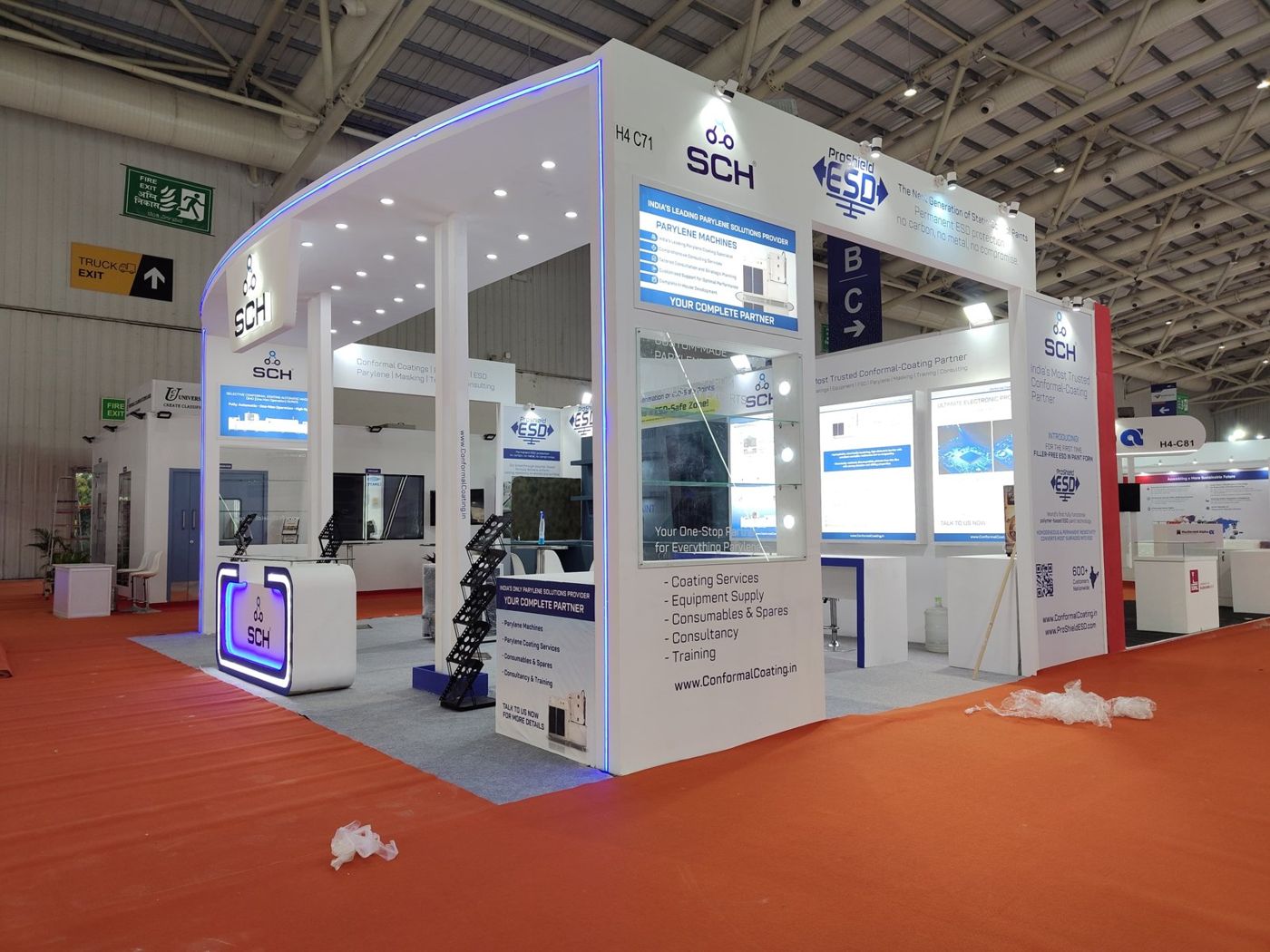 SCH stall with a white curved fascia edged in blue LED, a hanging backlit logo and a blue lit counter