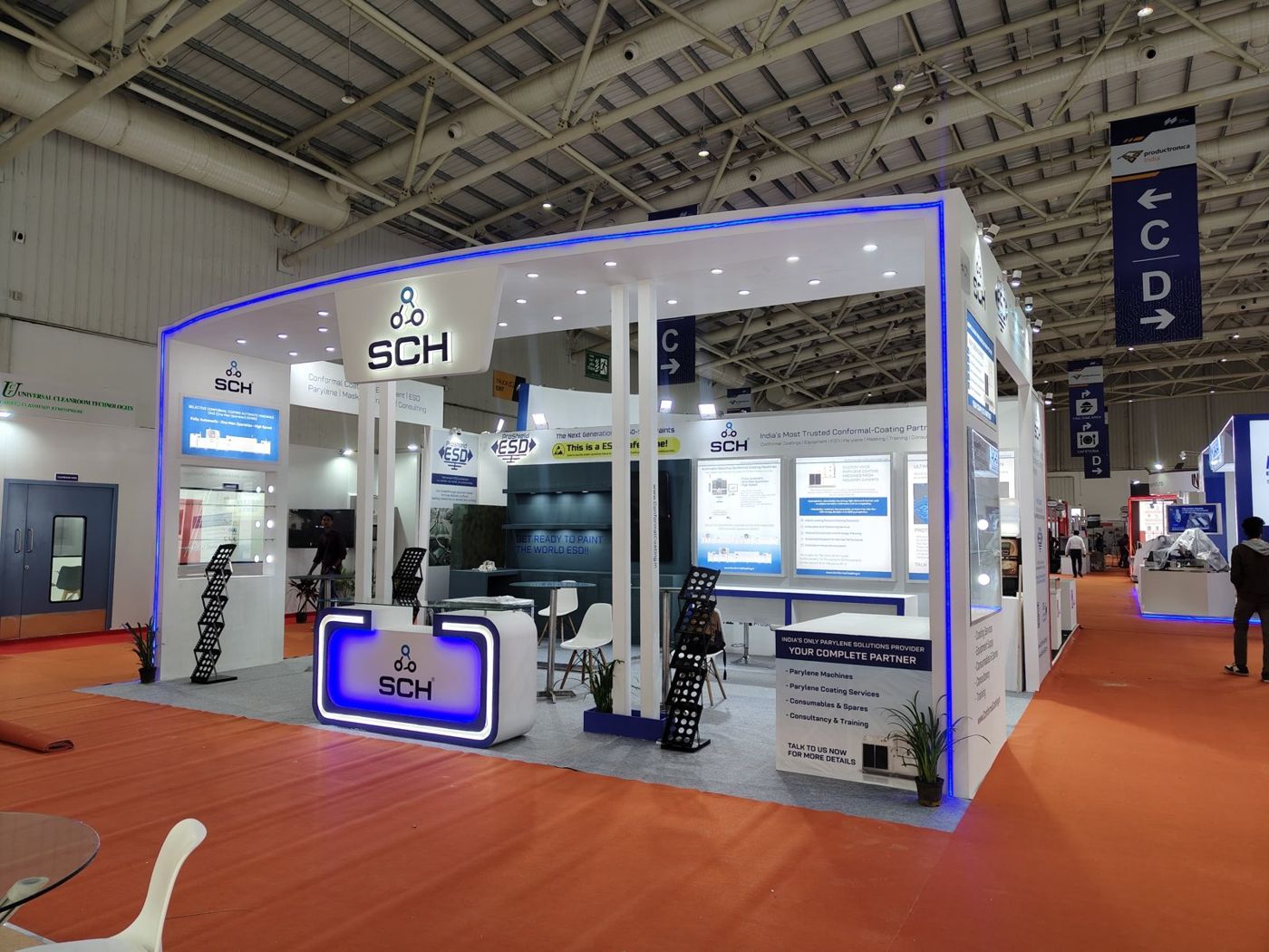 SCH stall with lightbox product panels, a dark grey ESD feature wall and the blue lit reception counter