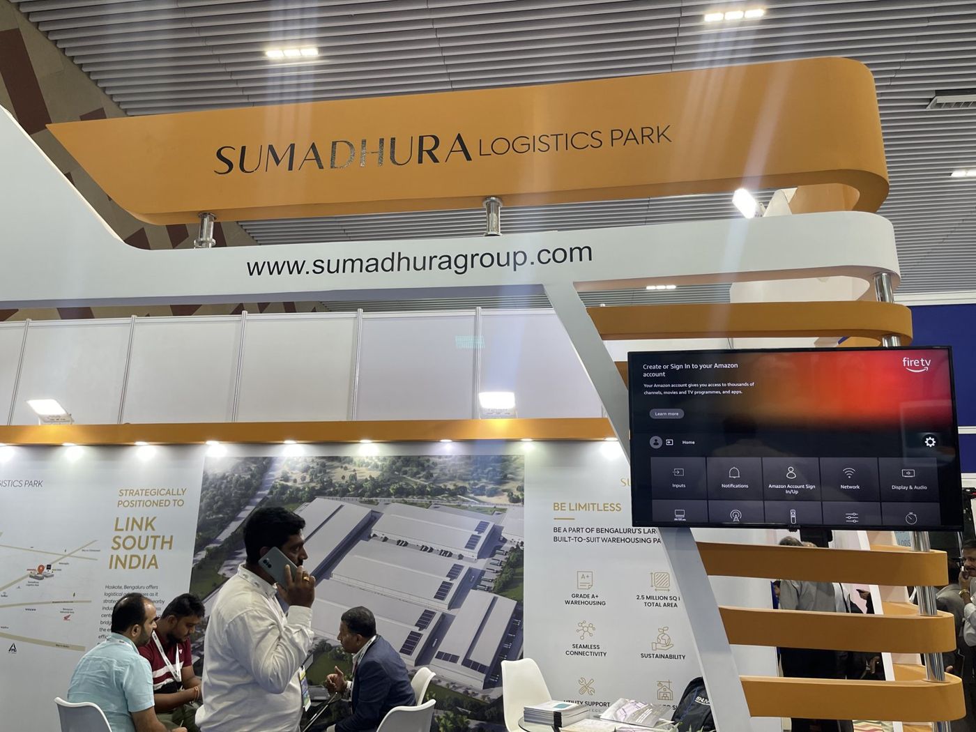 Close view of the curved mustard Sumadhura Logistics Park banner on steel stand-offs above the fascia