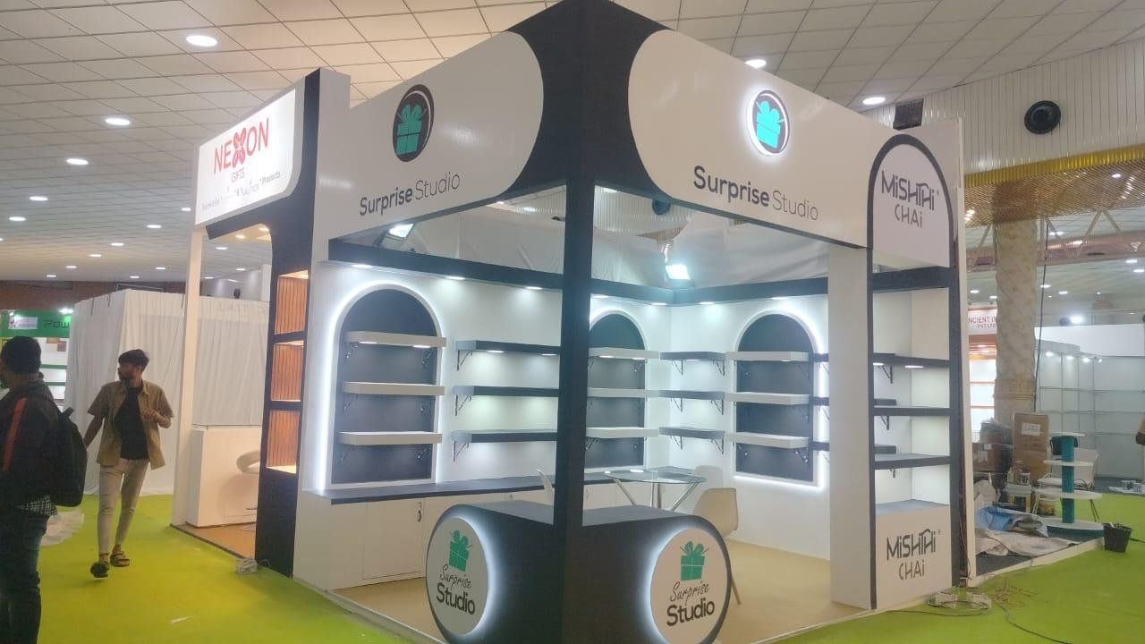 Black and white Surprise Studio stall with LED-outlined arched niches and a round backlit counter