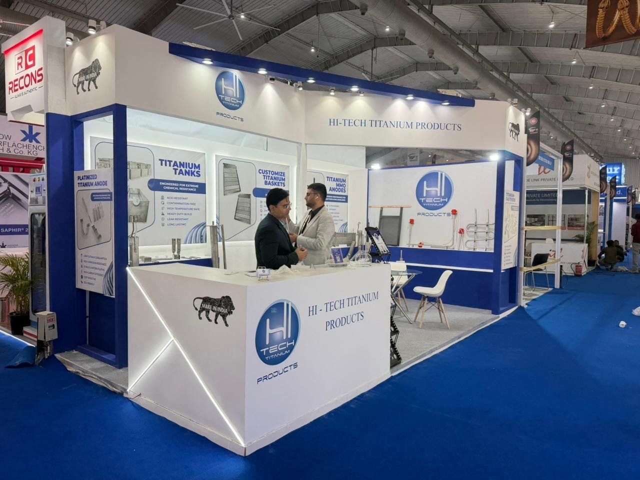 Corner view of the stall with LED-lined white counter, Make in India graphic and titanium samples