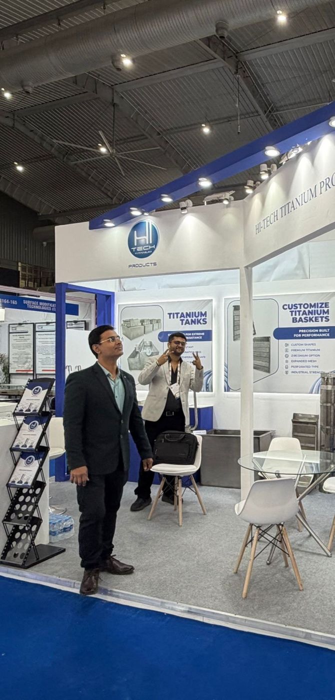Team inside the stall beside titanium tanks and baskets graphics with a literature stand