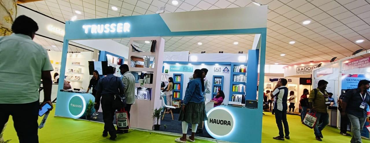 Trusser and Hauora stall with backlit sign, round lit counters and busy aisle