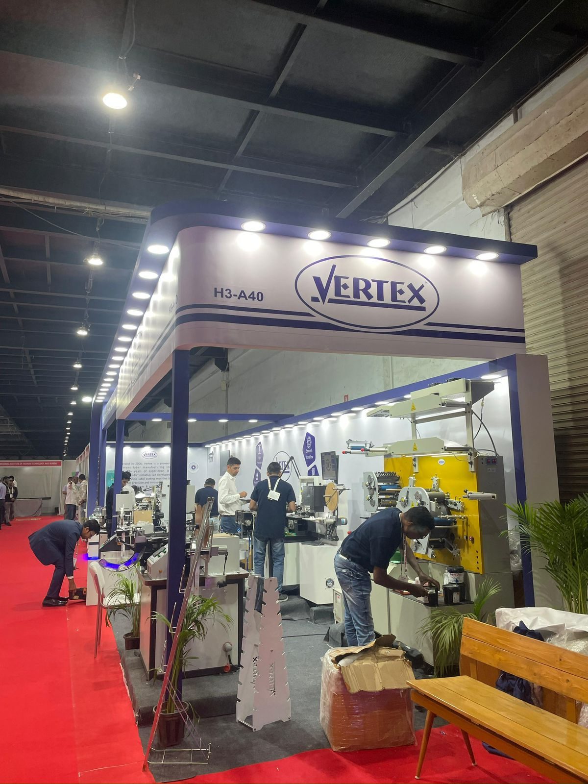 Vertex compact stall with lit curved fascia and machines inside