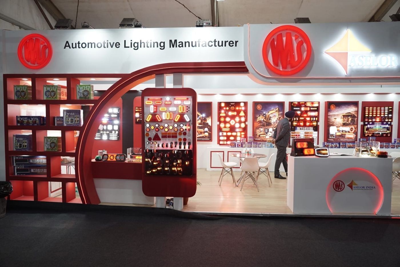 WAS automotive lighting stall with a red arch, red cube shelving and a tall panel of working vehicle lamps
