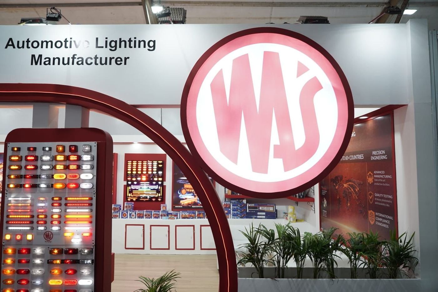 Close view of the circular WAS logo and the lamp panel, with an info graphic wall inside the stall