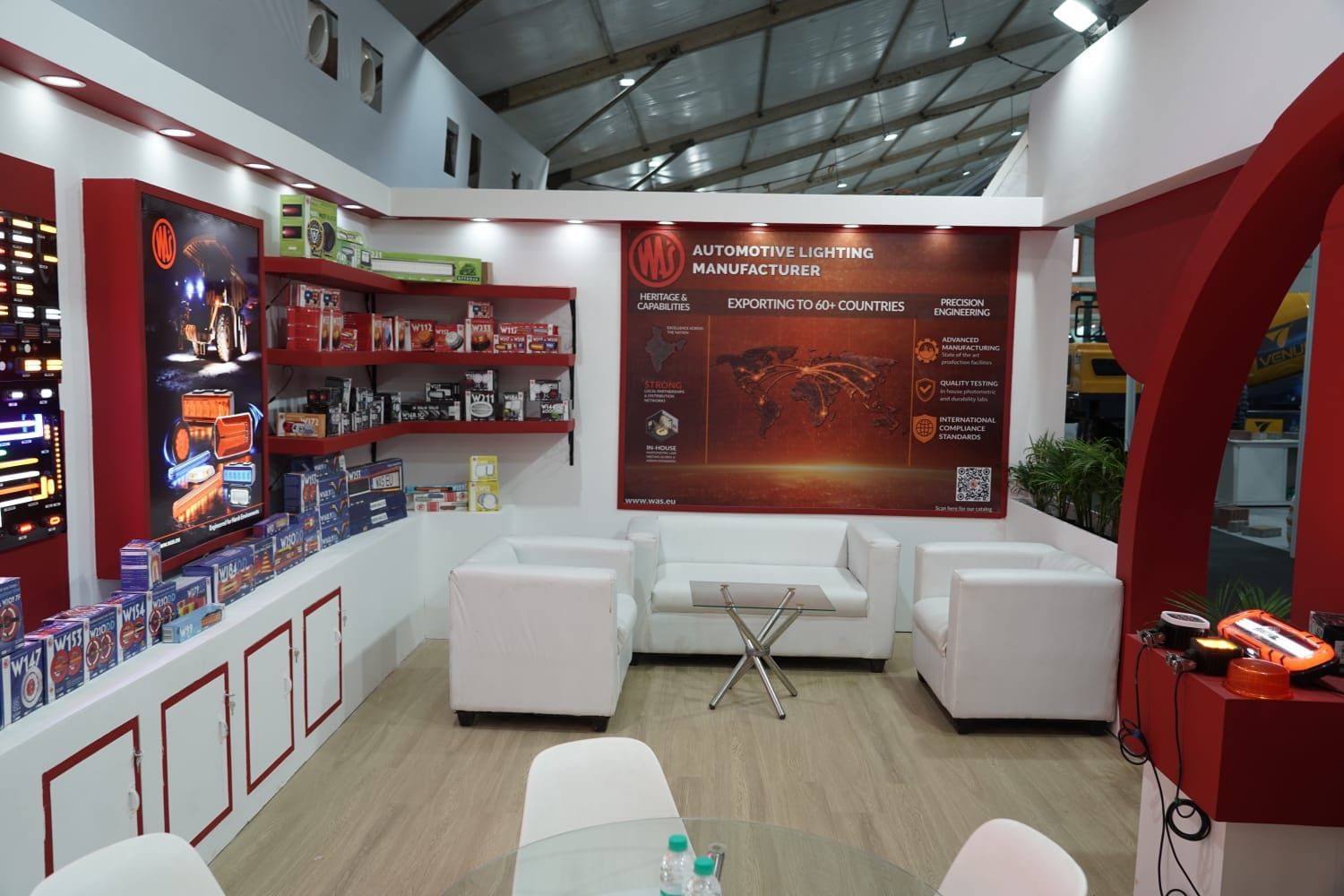 Automotive lighting stall lounge with red shelving and white sofas